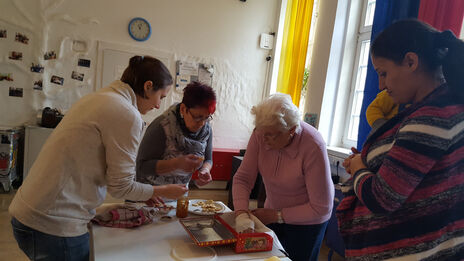 Frauen des Frauencafé bereiten Tisch für gemeinsames Essen vor