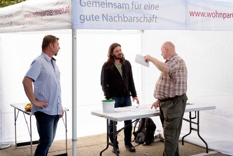 Besucher im Gespräch mit wohnpartner-Mitarbeiter