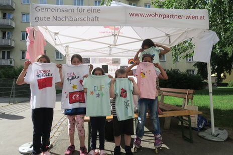 Kinder bei Zeit für Kreativität bemalen T-Shirts und Leinwände