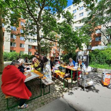 Frauen des Frauencafés beim gemeinsamen Zeichenworkshop im Hofe des Gemeindebaus Lechnerstraße 2-4-