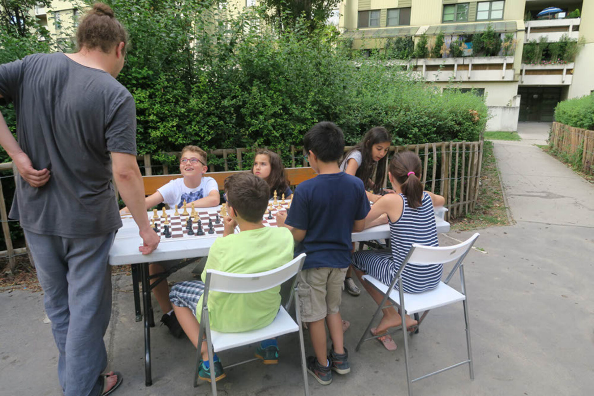 25 Kinder und zwei Erwachsene wechseln sich an den Brettern ab und haben viel Spaß dabei.