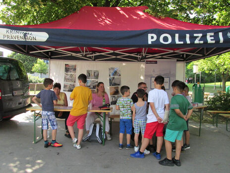 Viele Kinder besuchen den Stand der Polizei.