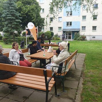 BewohnerInnen sitzen beim Nachbarschaftscafe zusammen