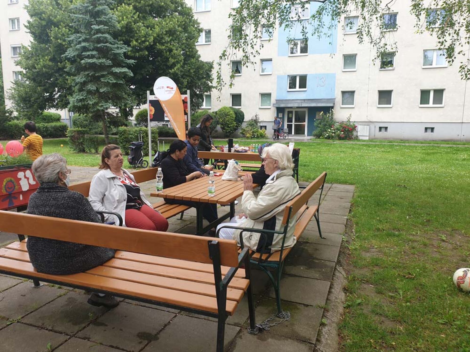 BewohnerInnen sitzen beim Nachbarschaftscafe zusammen