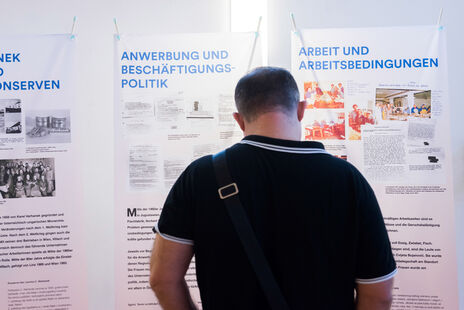 Besucher liest Ausstellungstafel