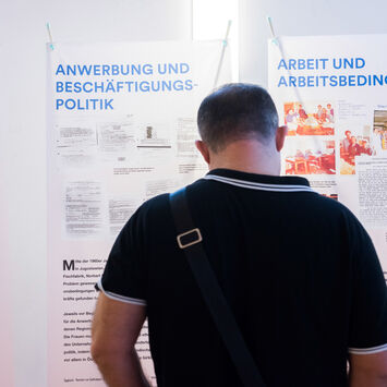 Besucher liest Ausstellungstafel