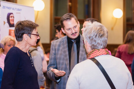 Drei Personen unterhalten sich bei der Ausstellung