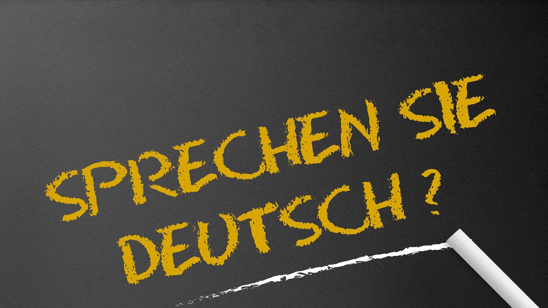 Schriftzug "Sprechen Sie deutsch?" auf einer Tafel, mit Kreide geschrieben