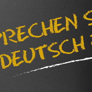 Schriftzug "Sprechen Sie deutsch?" auf einer Tafel, mit Kreide geschrieben