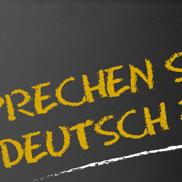 Schriftzug "Sprechen Sie deutsch?" auf einer Tafel, mit Kreide geschrieben