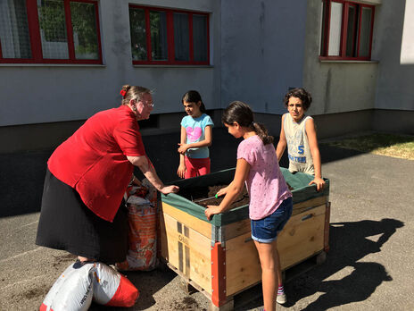 Erwachsene halfen den Kindern beim Befüllen mit Erde.