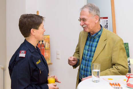 Besucher im Gespräch mit Polizistin